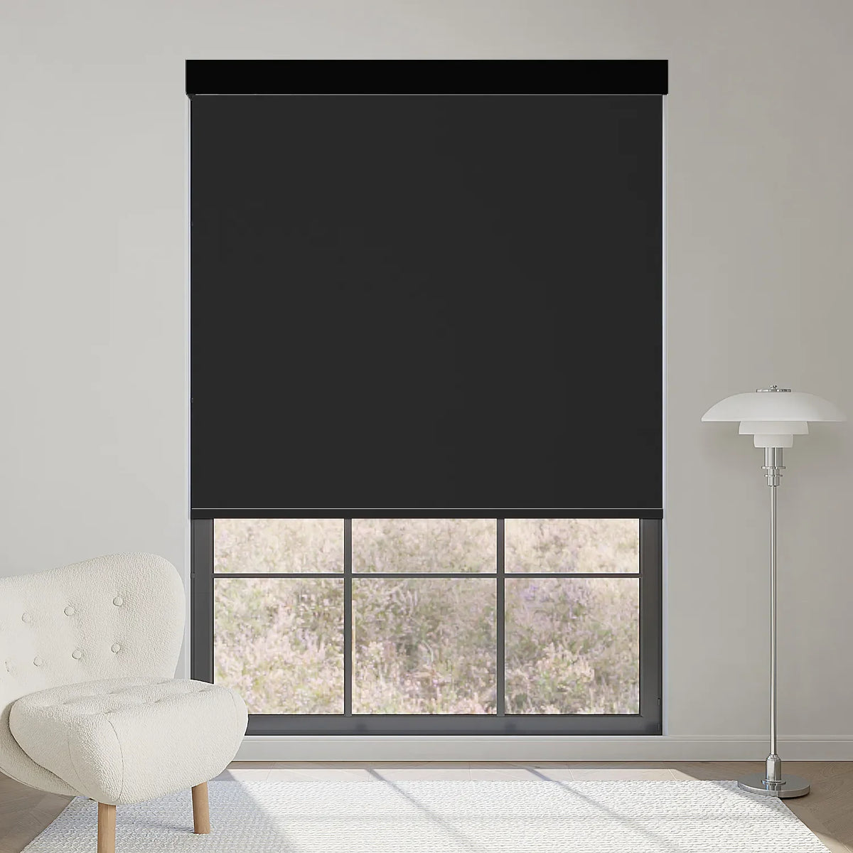 Motorized black vinyl blackout roller shade stopped halfway, blocking strong sunlight while softening indoor light.