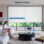 "Female homeowner reading at home, using Alexa voice control to adjust the light filtering level of motorized custom roller shades."