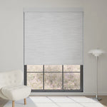 Foggy grey textured motorized blackout roller shade softens sunlight while maintaining outdoor view, adding subtle elegance to the room.