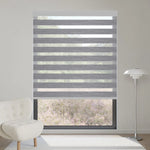 Luxury grey motorized zebra shade blocks 90% sunlight, creating a refined, layered lighting effect indoors.